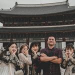 Visitors pose playfully at Gyeongbokgung Palace in Seoul, a famous Korean landmark.